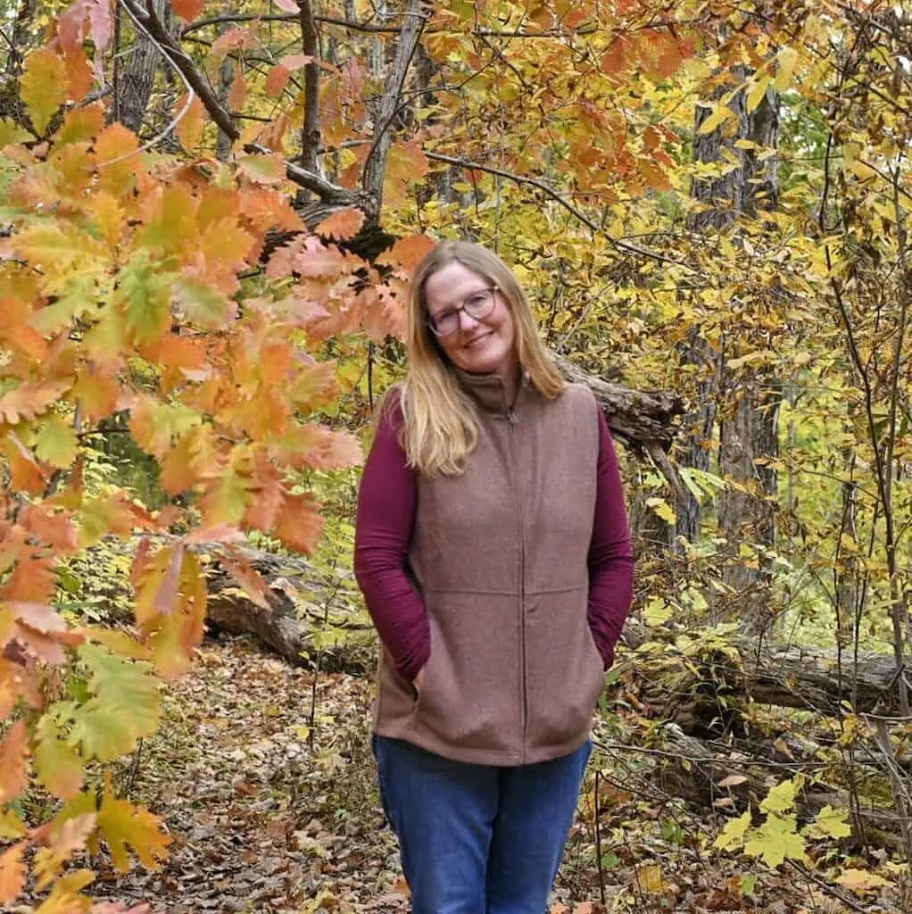 Profile Image of Tara Schatz surrounded by fall foliage.