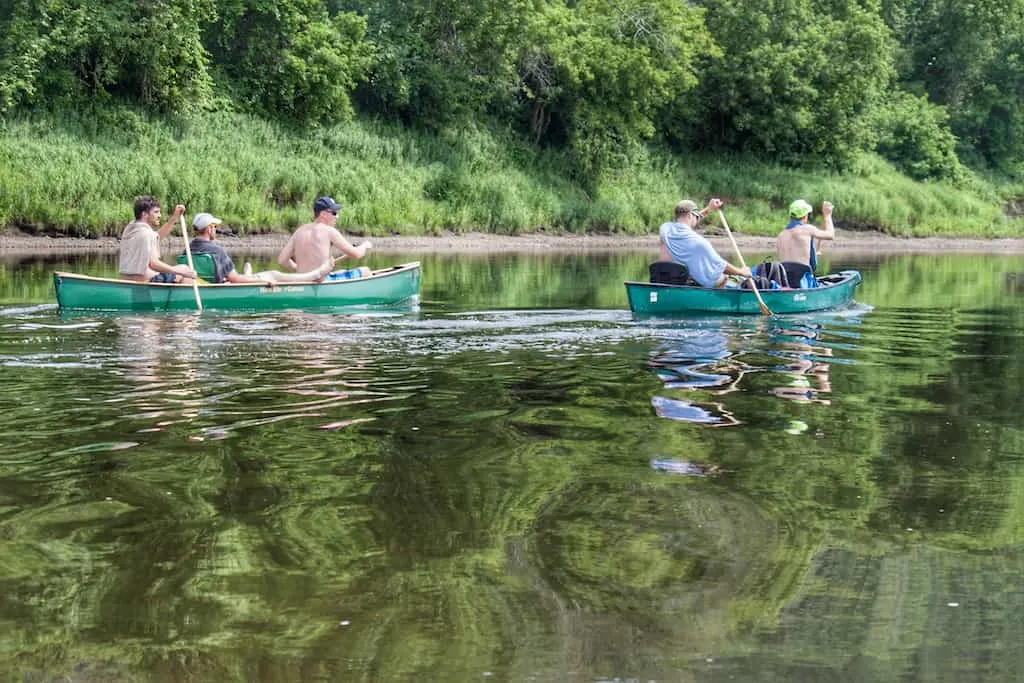 Two canoes paddling on the Connecticut River in Vermont.