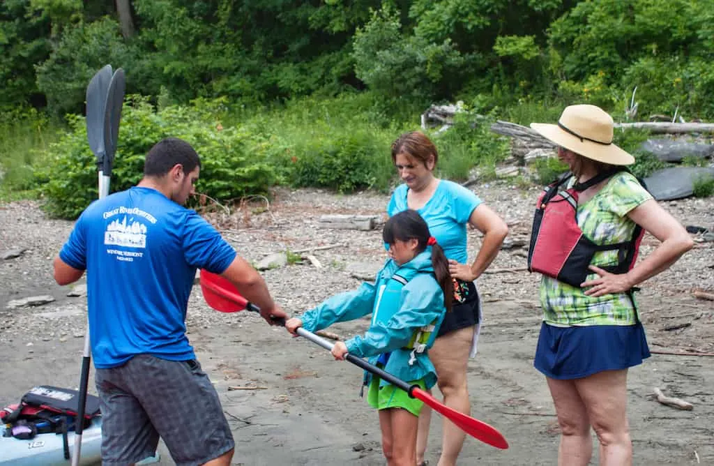 A man from Great River Outfitters shows us how to hold a kayak paddle.