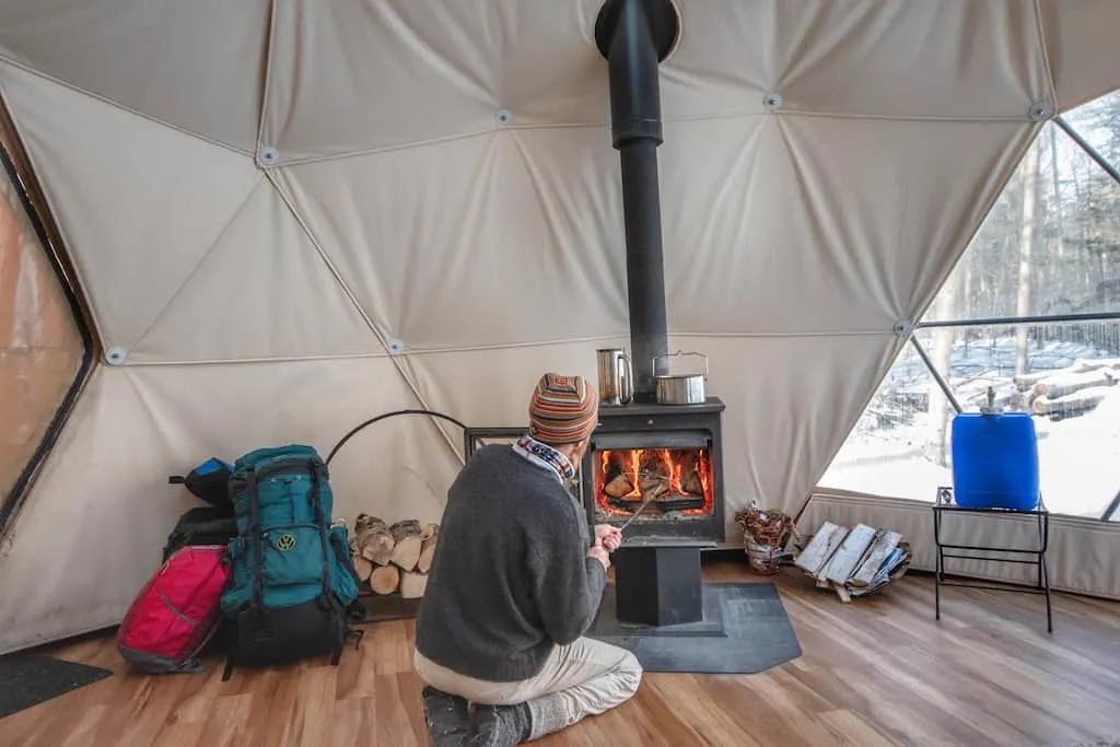 loading the woodstove in the geodesic dome in Putney, Vermont.