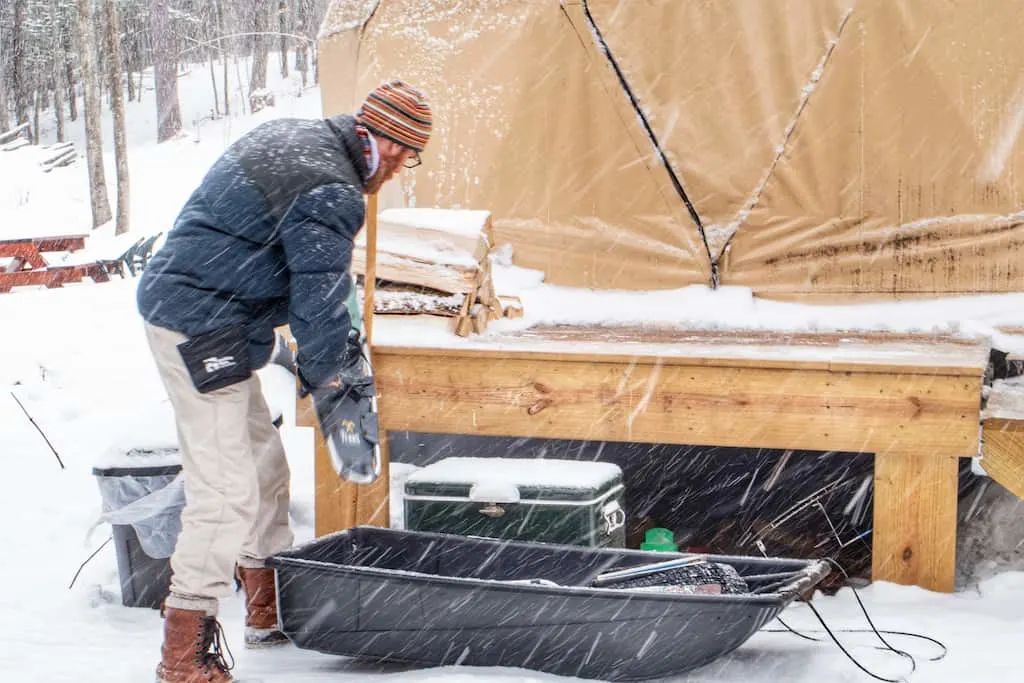 Eric unloading our gear from the provided sled next to the dome.