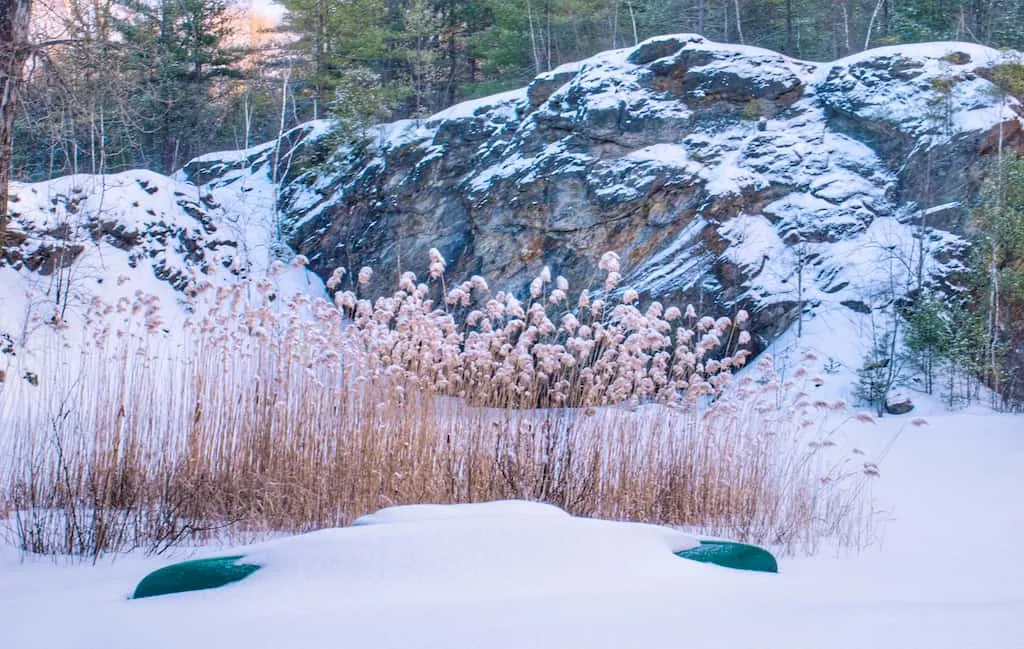 A turned over canoe covered in snow.