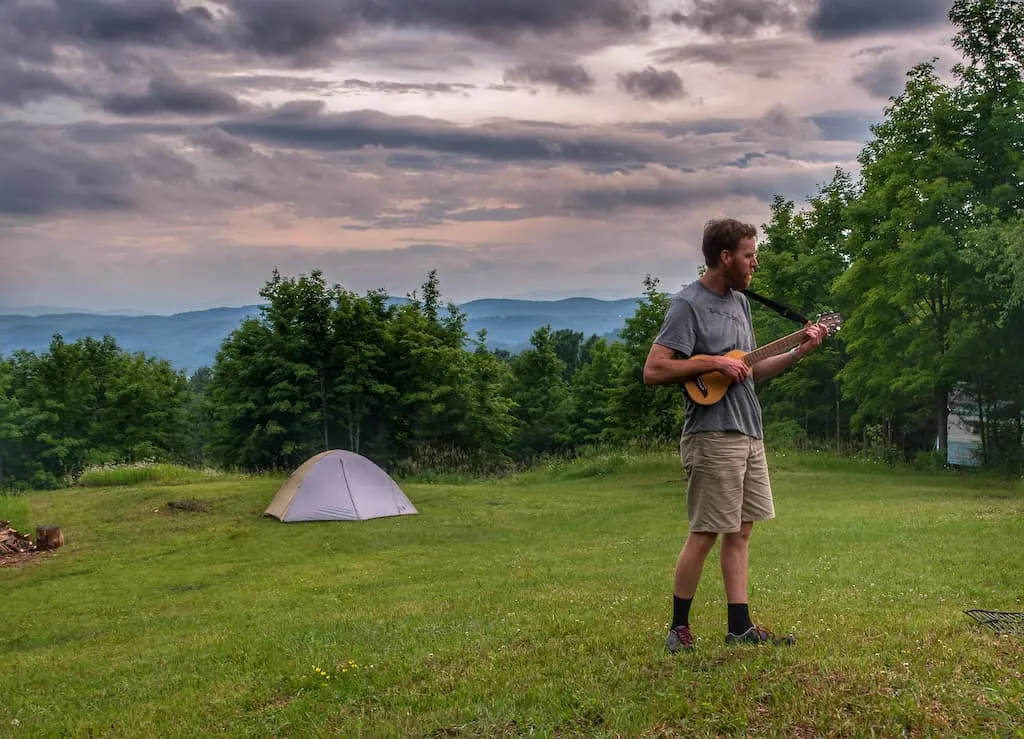 Eric playing his travel guitar as the sun goes down at Mountain Home Tent sites in Tunbridge, Vermont.
