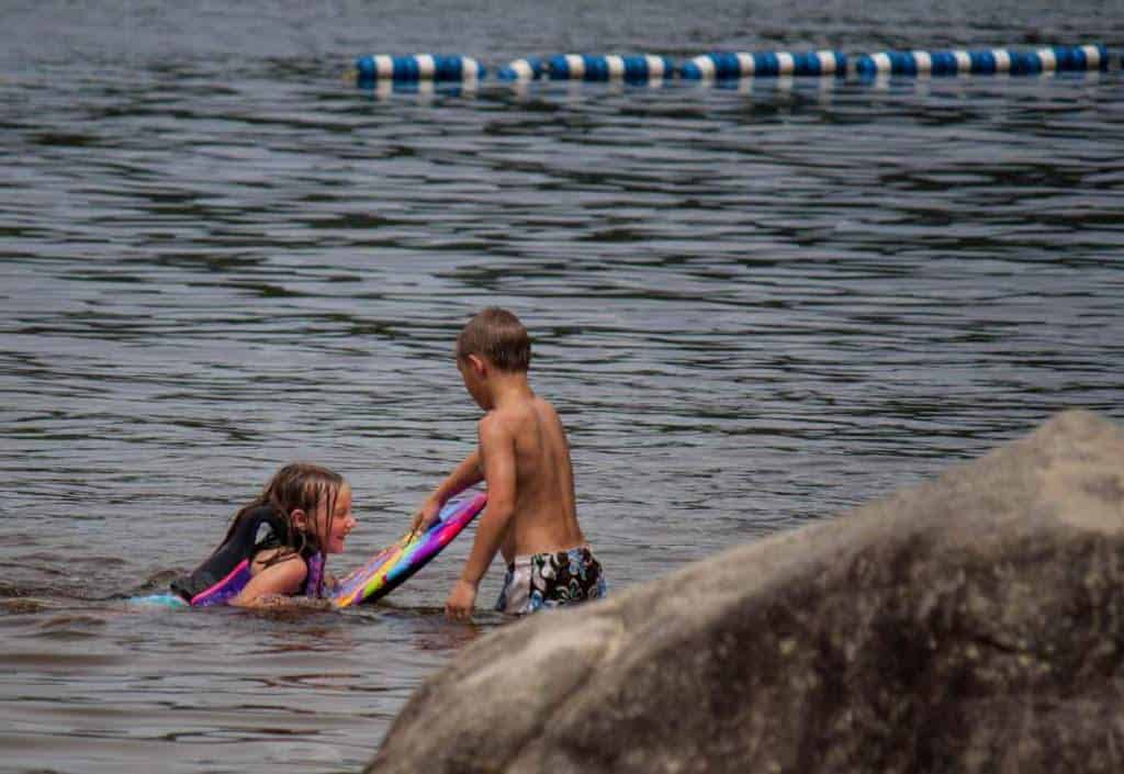 two kids swimming at Boulder Beach State Park in Vermont.