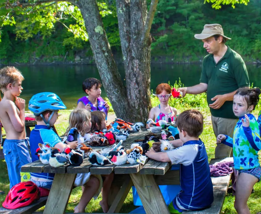A park interpreter talks with a group of kids about bird migration at Little River State Park in VT.