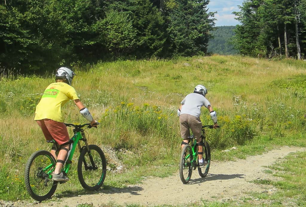 Two teenagers ride a mountain bike trail at Mount Snow in Vermont. 