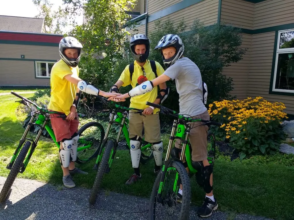 3 guys stand over rented mountain bikes at Mount Snow in West Dover, Vermont.