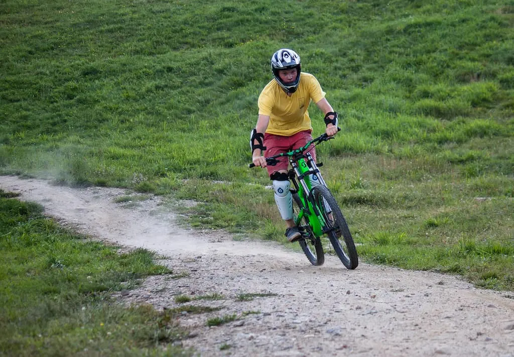 A young man rides a mountain bike on a dirt trail in Vermont.