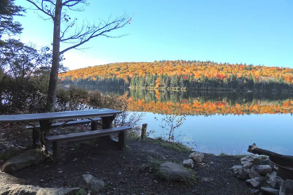 A fall foliage view from one of the waterfront campsites on Grout Pond in Vermont.