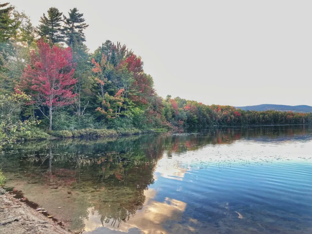 An autumn view of Spectacle Pond from the beach at Brighton State Park in Vermont.