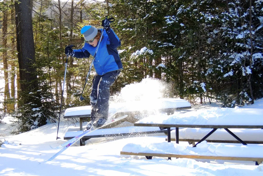 A boy uses a picnic table as a ski jump in Woodford State park, Vermont.