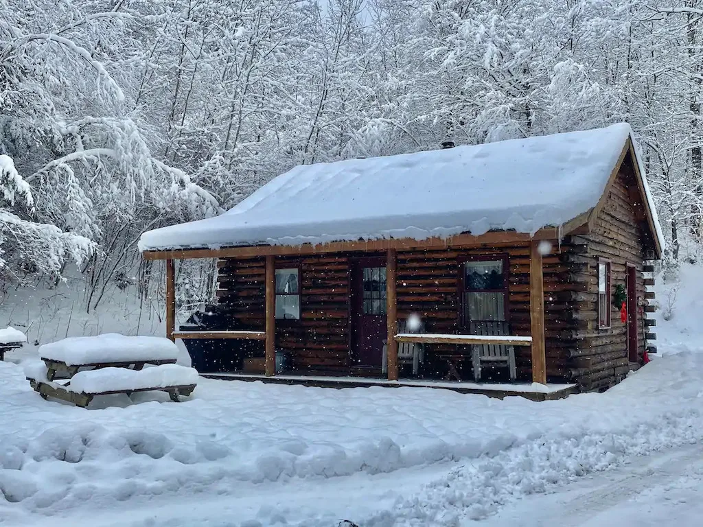 A log cabin covered with snow in Vermont.