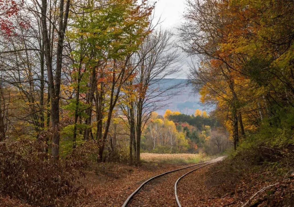 A curved railroad track through Vermont fall foliage in North Bennington, Vermont.