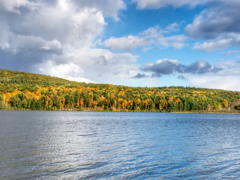 The loop around Colchester Pond is one of the best easy hikes near Burlington, Vermont. This view is during the fall foliage season.