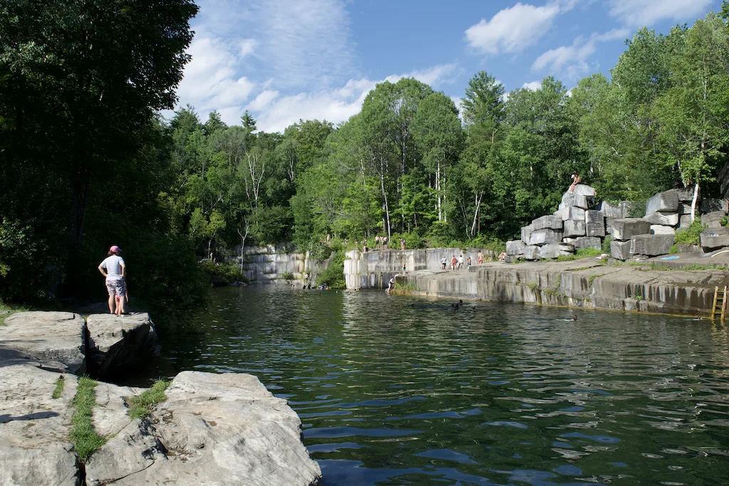 A group of people gathers at the Dorset Quarry swimming hole on a hot summer day in Vermont.