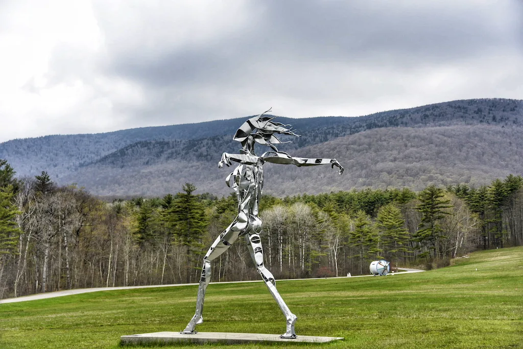 A later winter view of an outdoor sculpture of a larger-than-life woman made of steel. Located on the grounds of Southern Vermont Arts Center in Manchester, Vermont.