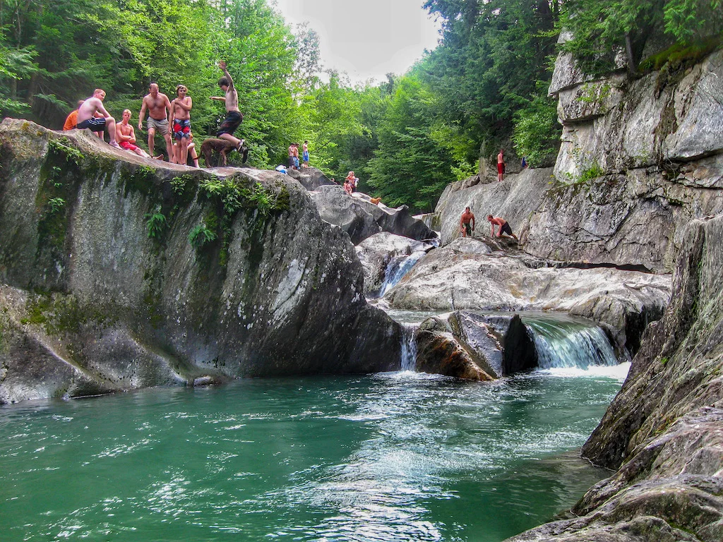 A group of people enjoys Warren Falls in Warren, Vermont.