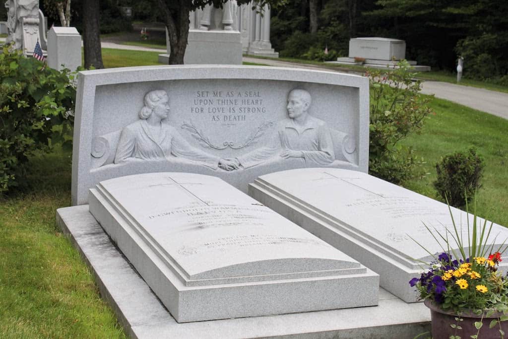 A memorial in Hope Cemetery featuring two people holding hands in bed - carved out of granite.