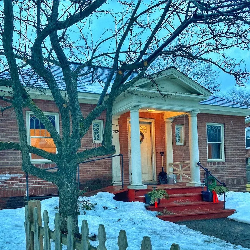 The front of a brick home in Quechee Vermont that is also a vacation rental.