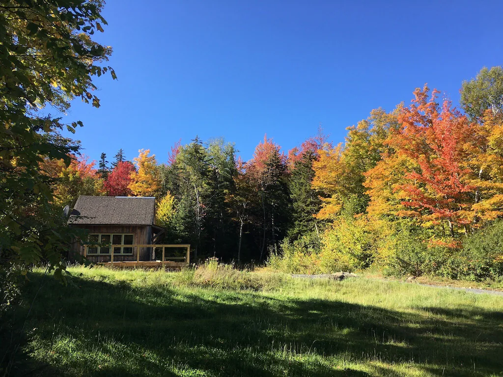 An off-grid cabin in Vermont surrounded by fall foliage. 