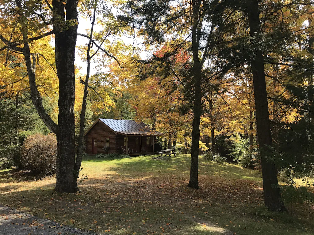 One of several small cabins in Vermont surrounded by beautiful fall foliage. 