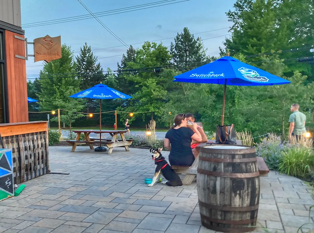 A couple sits on a dog-friendly patio at Switchback Brewing in Burlington Vermont.