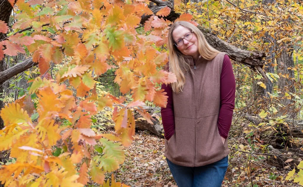 Tara standing in front of a colorful oak tree in the fall.