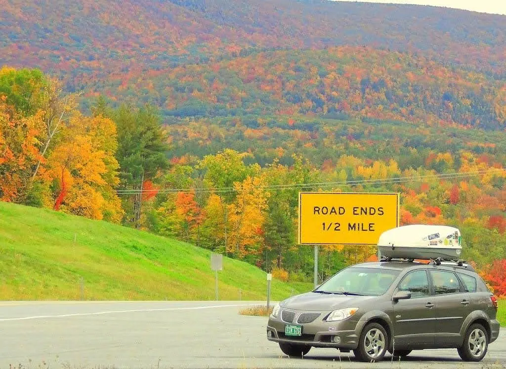 A small car in front of a sign that says Road Ends 1/2 mile.