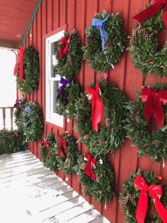Northern Llama Co wreaths on display on a red wall 