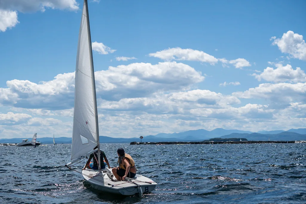 A child maneuvers a small sail boat on Lake Champlain with the Community Sailing Center. 
