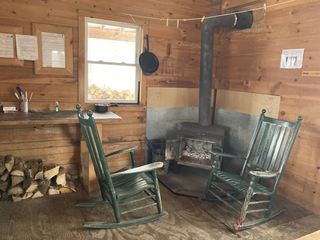 Two rocking chairs in front of a woodstove in a cabin in Vermont. 