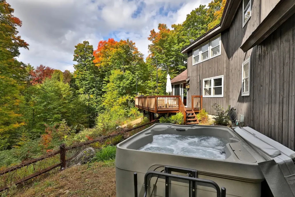 A hot tub in the wooded backyard of a Vermont vacation rental. 
