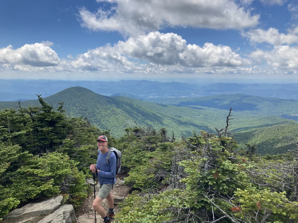 The author's spouse standing on a rocky outcrop on Killington Peak in Vermont. 