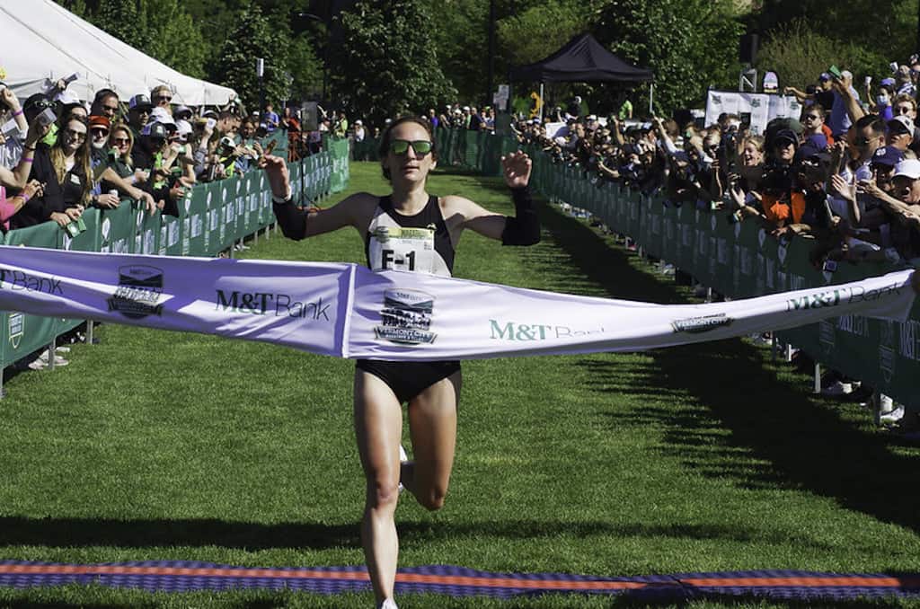 A woman athlete crossing the finish line during Vermont City Marathon.