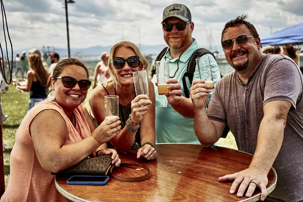 A group of friends drink a toast outdoors at the Vermont Brewers Festival on the Burlington waterfront. 