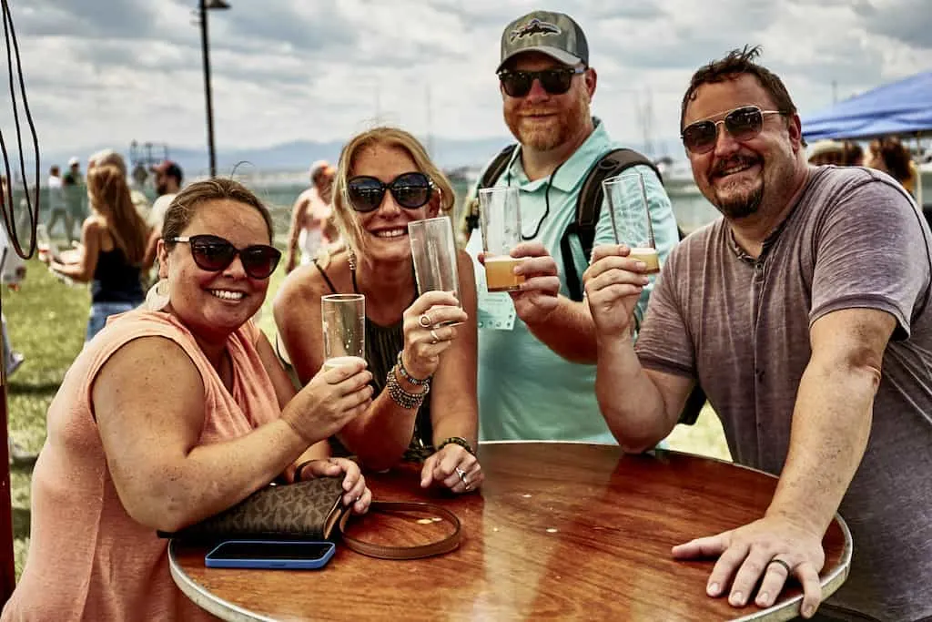 A group of friends drink a toast outdoors at the Vermont Brewers Festival on the Burlington waterfront. 
