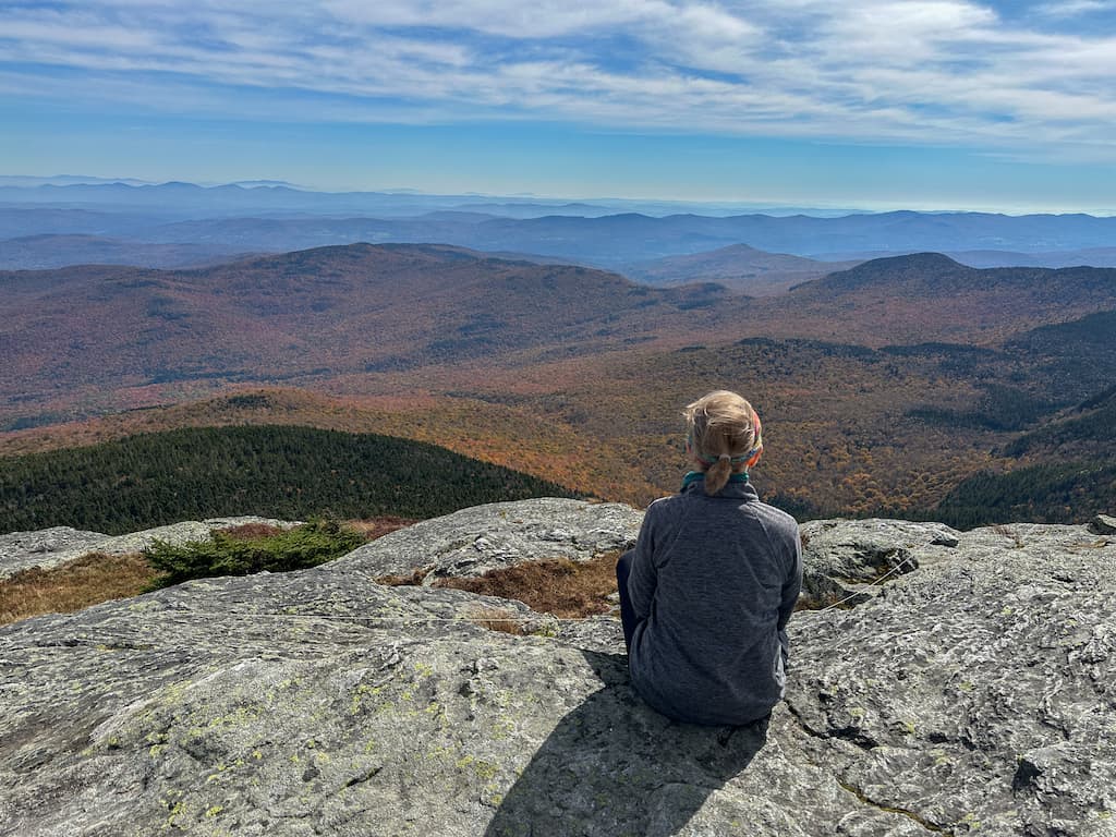 Julie sits on the top of Camel's Hump and enjoys the view.