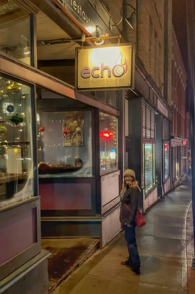 Tara standing underneath a sign that says Echo Restaurant and Lounge.