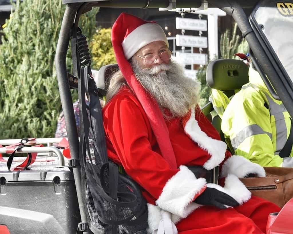 Santa sitting in a golf cart. 