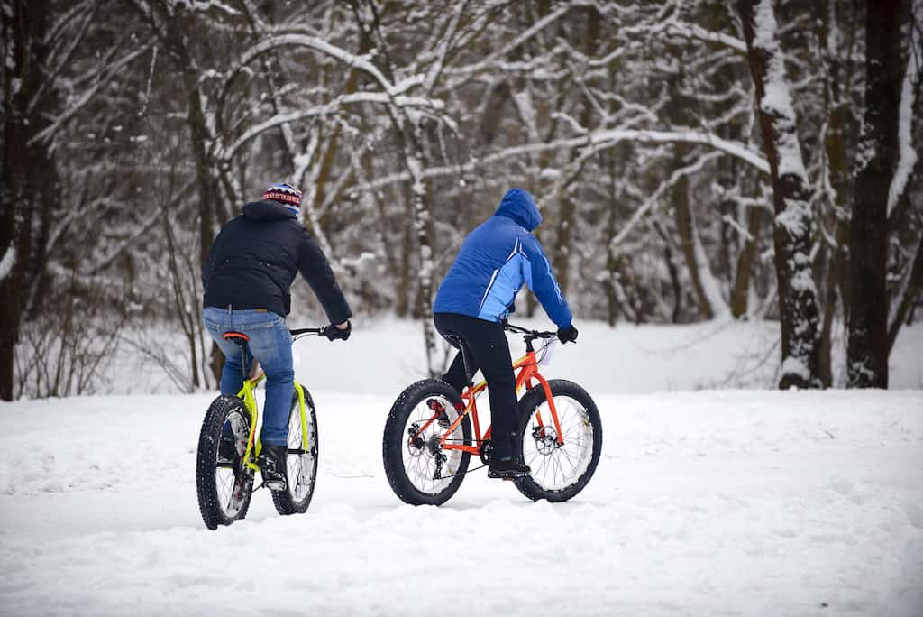 Two men fat biking  across the snow in Vermont. 