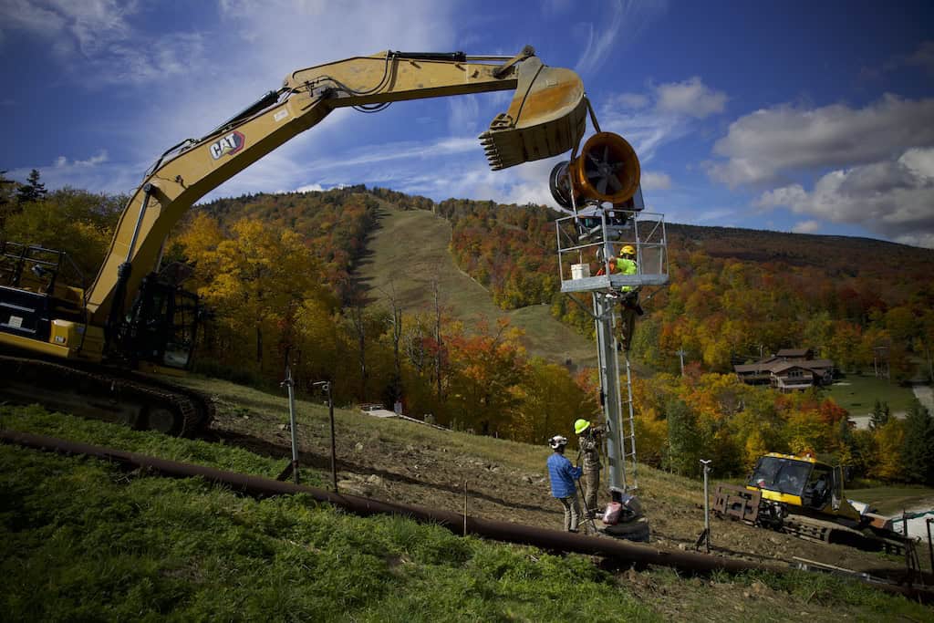 Workers install snowmaking equipment at Killington Resort. 