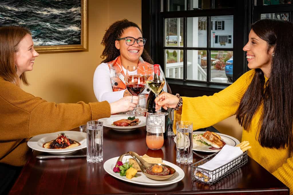 Three women enjoy dinner at The Left Bank in Weston