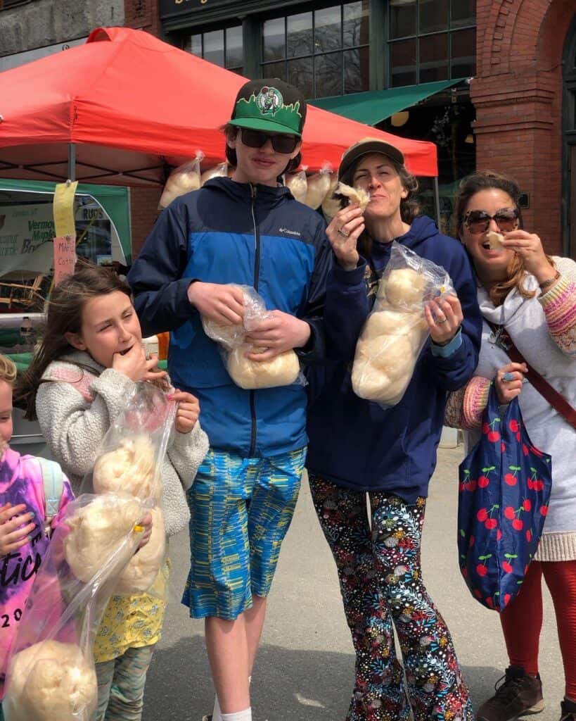 A group of kids and adults eating maple cotton candy. Photo credit: Discover St. Johnsbury.