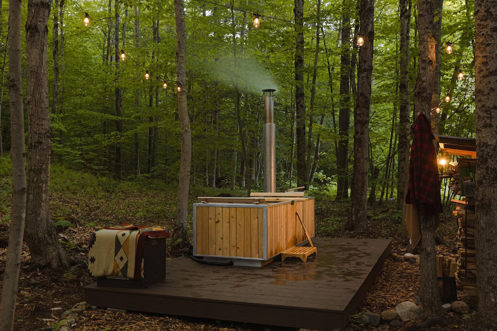 A wood-fired hot tub in the woods at Tanglebloom Cabin in Brookline, Vermont.