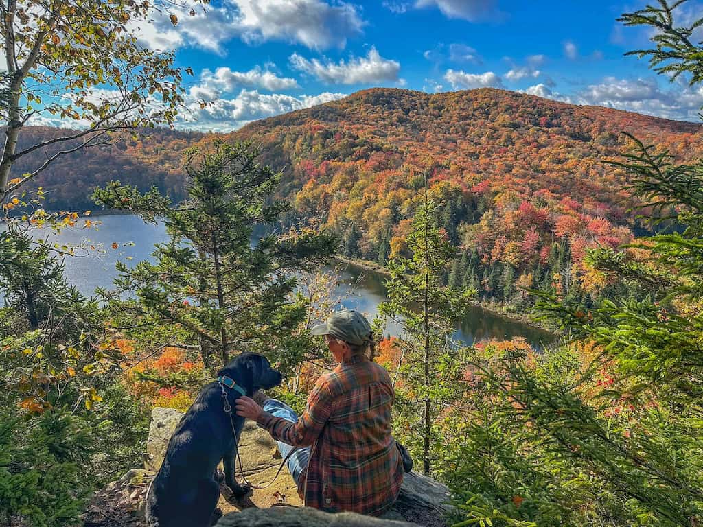 Tara sits with black lab Malinda at the Oleary Leap Lookout in the Northeast Kingdom of Vermont.