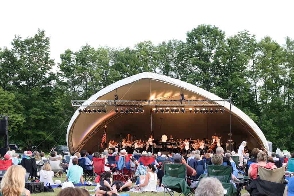An outdoor stage featuring a Vermont Symphony Orchestra concert.