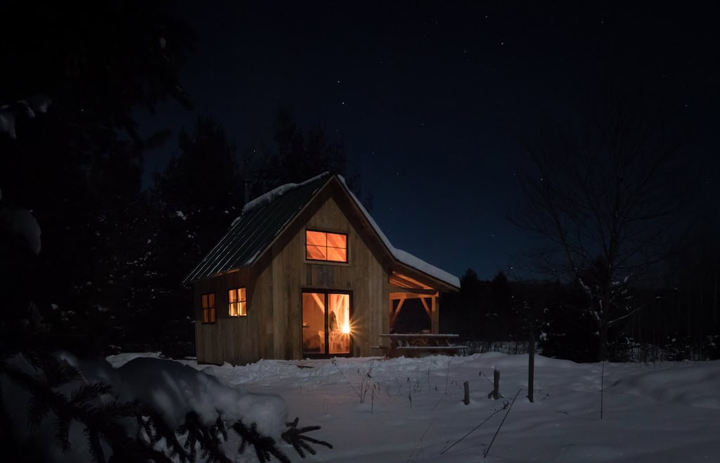 Nulhegan Hut on a snowy winter night in Vermont.