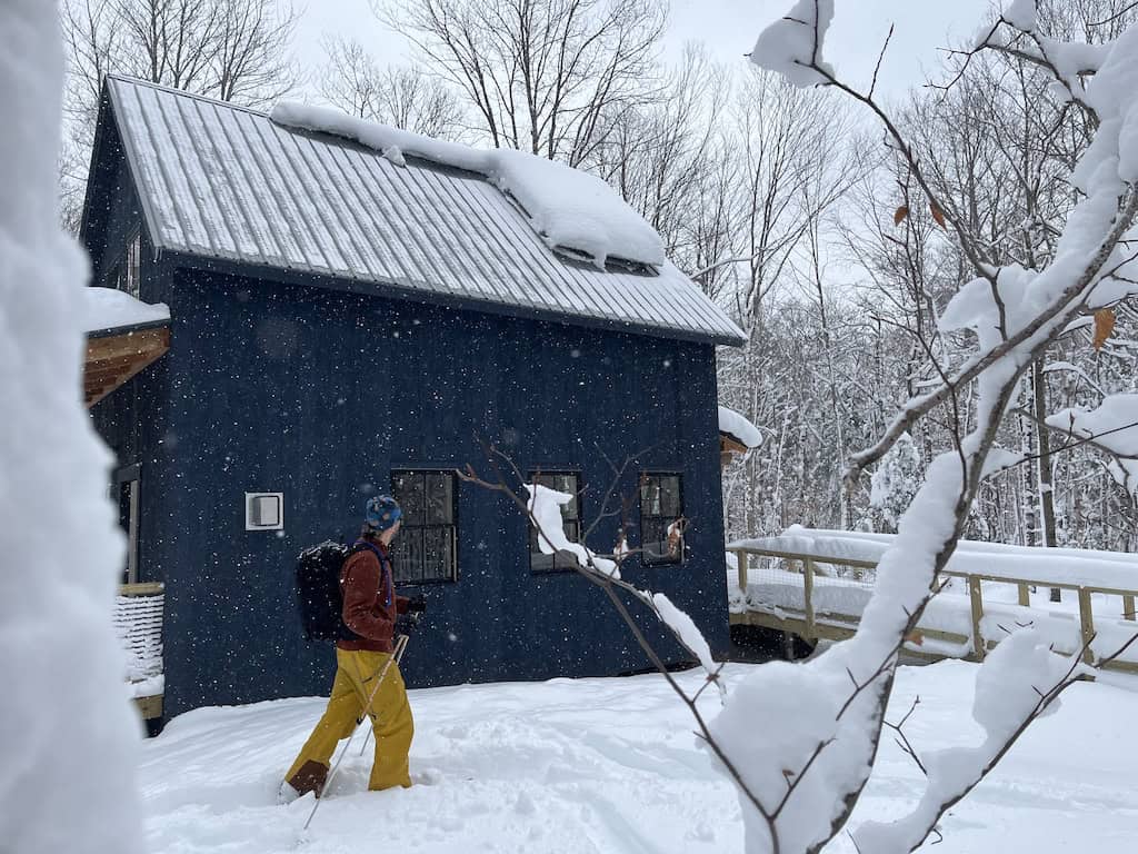A skier glides through the snow in front of the Grout Pond Hut in Stratton, Vermont.
