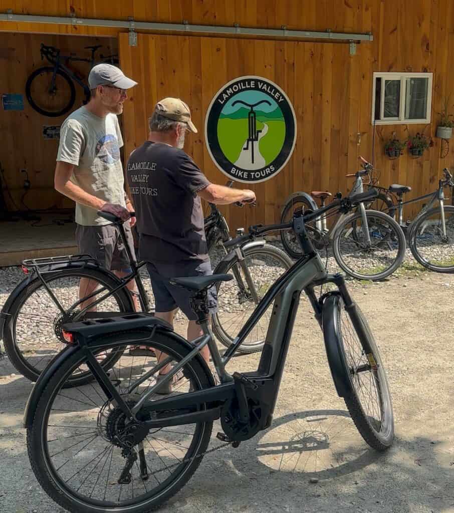Brian is a bike specialist with Lamoille Valley Bike Tours. He's showing Eric how the display works on his bike. 
