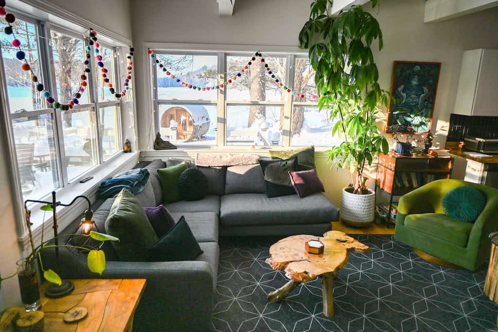 The light-filled living room with the sauna and lake in the background. 